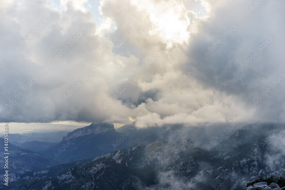 sun setting over the mountains on a cloudy day