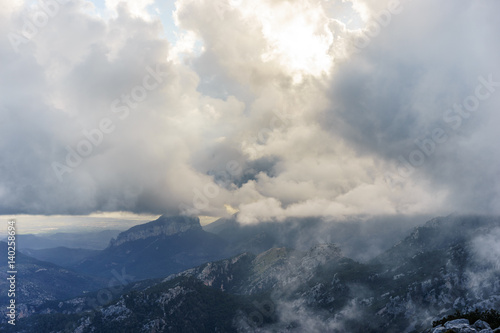 sun setting over the mountains on a cloudy day