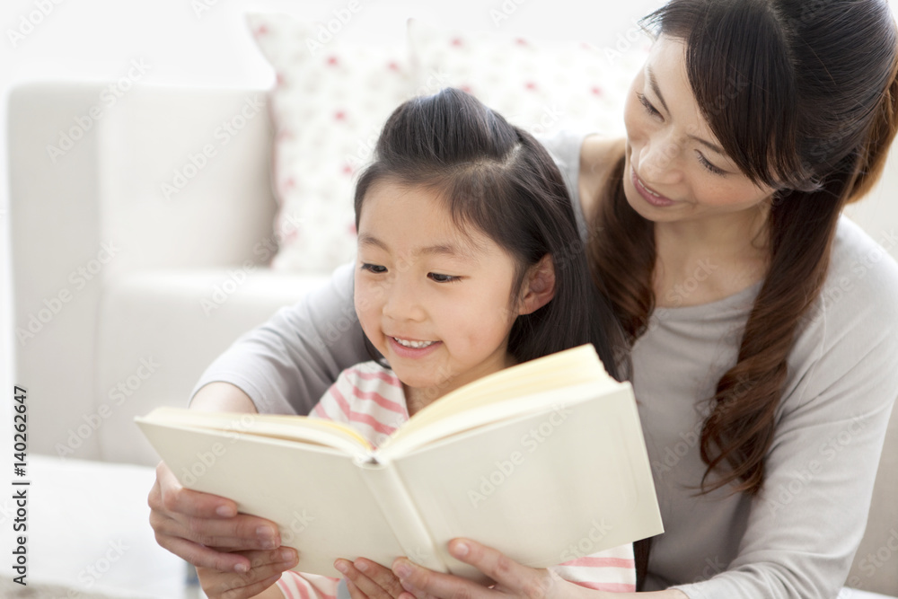 Mother and daughter reading a book together Mother and daughter reading a book together
