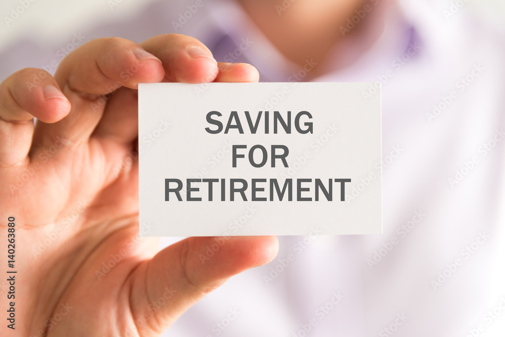 Businessman holding a card with SAVING FOR RETIREMENT message Businessman holding a card with SAVING FOR RETIREMENT message