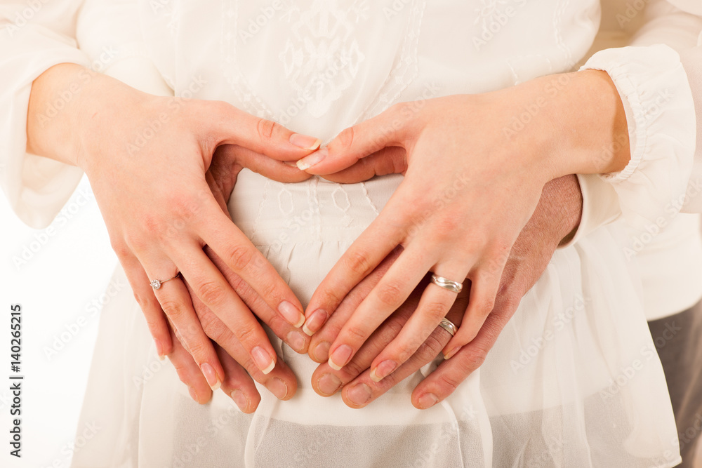 Man and pregnant woman holding hands on belly Man and pregnant woman holding hands on belly