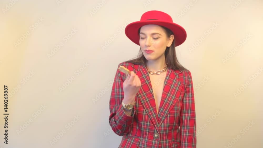 Young model in jacket and hat eats cookies and smiles Young model in jacket and hat eats cookies and smiles
