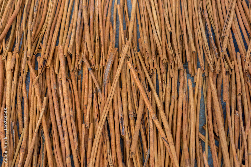 Fresh Cinnamon sticks out in the street drying in the midday sun. Viewed from above. Fresh Cinnamon sticks out in the street drying in the midday sun. Viewed from above.