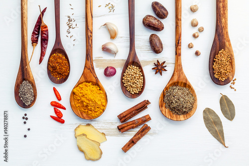 Fototapeta Naklejka Na Ścianę i Meble -  Various of Indian spices and herbs in wooden spoons. Flat lay of spices ingredients chili ,paprika ,peppercorn, dried thyme, cinnamon,star anise and curry powder on the shabby wooden.