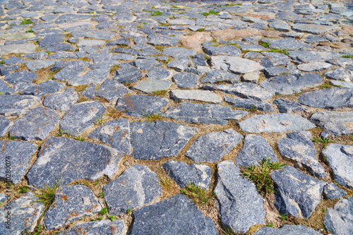 Stone floor. Large stone on the old road. Stone pavement from big cobblestone in perspective. Horizontal format.