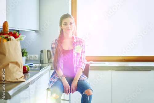 Beautiful woman cooking cake in kitchen standing near desk