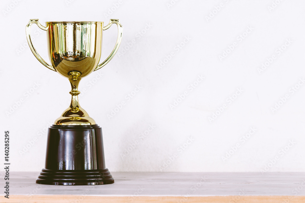 Golden trophy on wooden table with copy space Golden trophy on wooden table with copy space