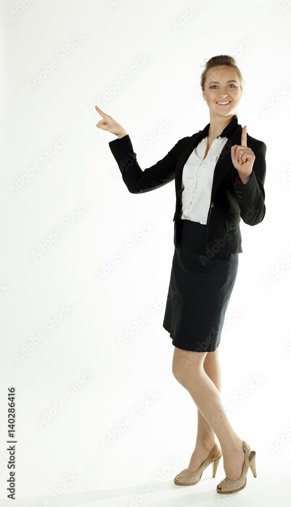 Smiling business woman draws attention ,shows finger up .White background
Smiling business woman draws attention ,shows finger up .White background
