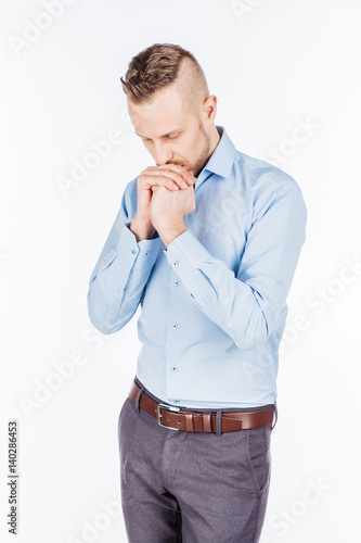bearded business man praying with hands. human emotion expression and lifestyle concept. image on a white studio background..