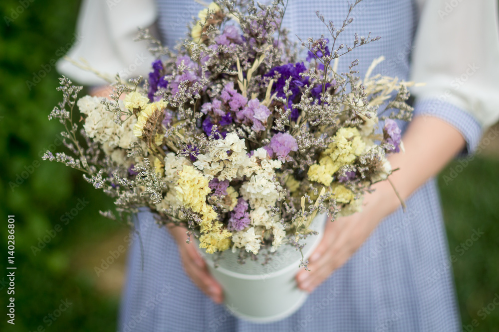 Woman hands holding a flower in green meadow focus on a flower Woman hands holding a flower in green meadow focus on a flower
