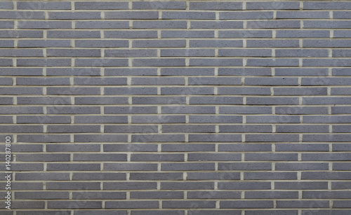 Warm grey brick wall texture background. Tiled
