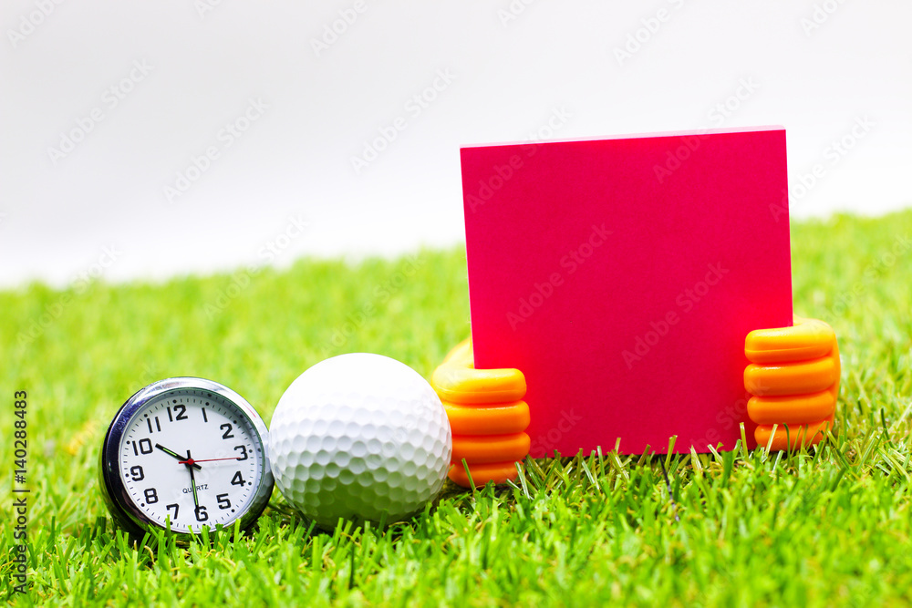 Naklejka premium Time for golf. Golf ball with clock are on green grass