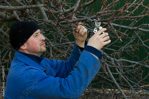 Happy gardener cuts the branch shears