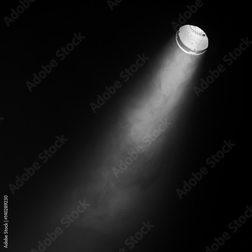 Ray of scenic spot light over black smoke photo