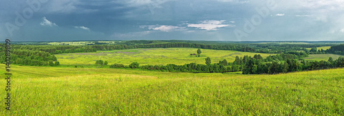 Summer panorama before a thunder-storm field a river and a forest in the distance, the Russian north