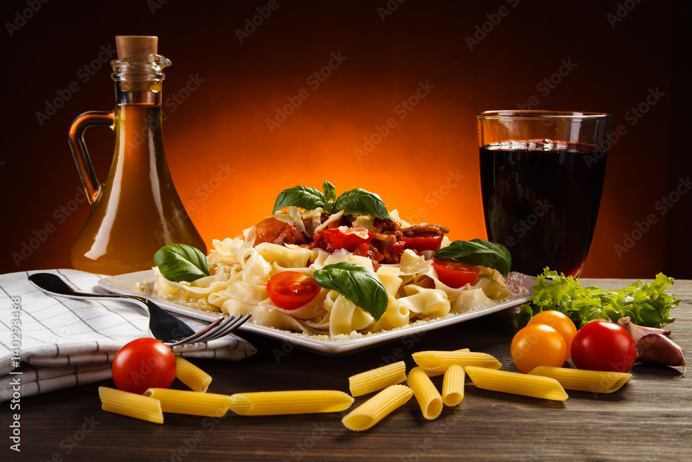 Pasta with tomato sauce and vegetables on table Pasta with tomato sauce and vegetables on table