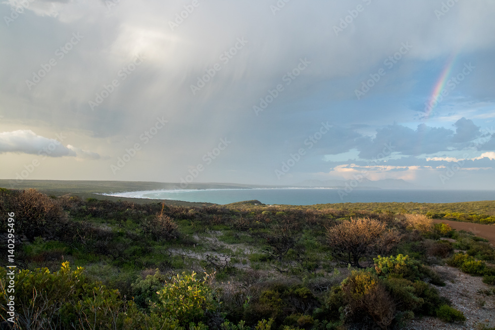 Rainbow and rain clouds over bay