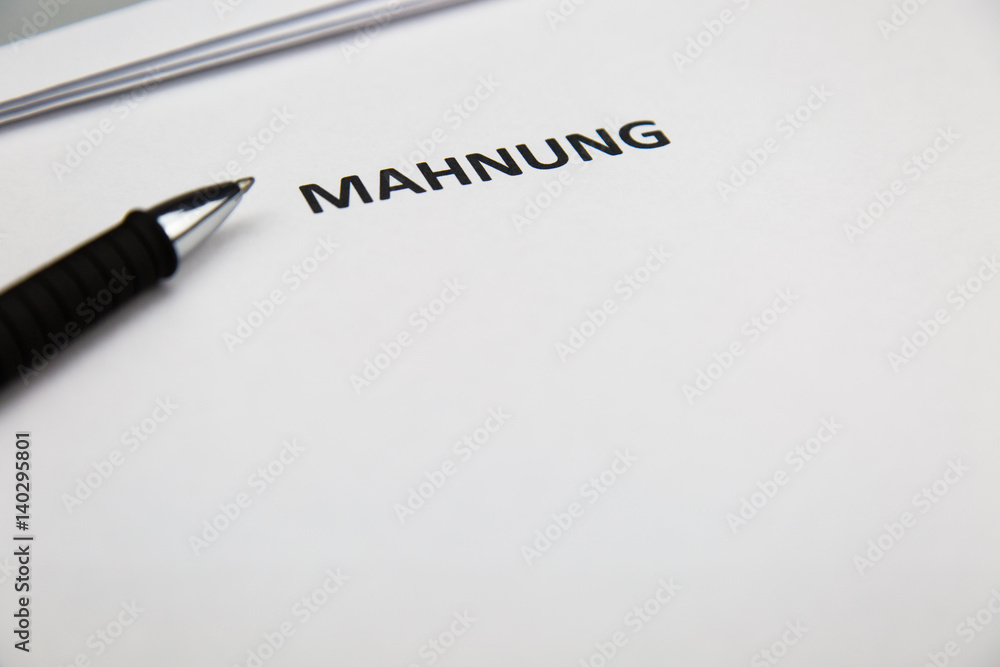 Mahnung mit Stift auf Blatt Mahnung mit Stift auf Blatt