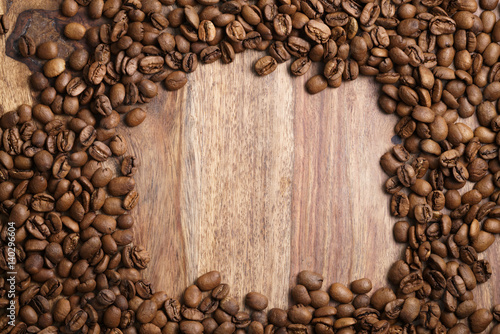 frame from roasted coffee beans on wood background, top view