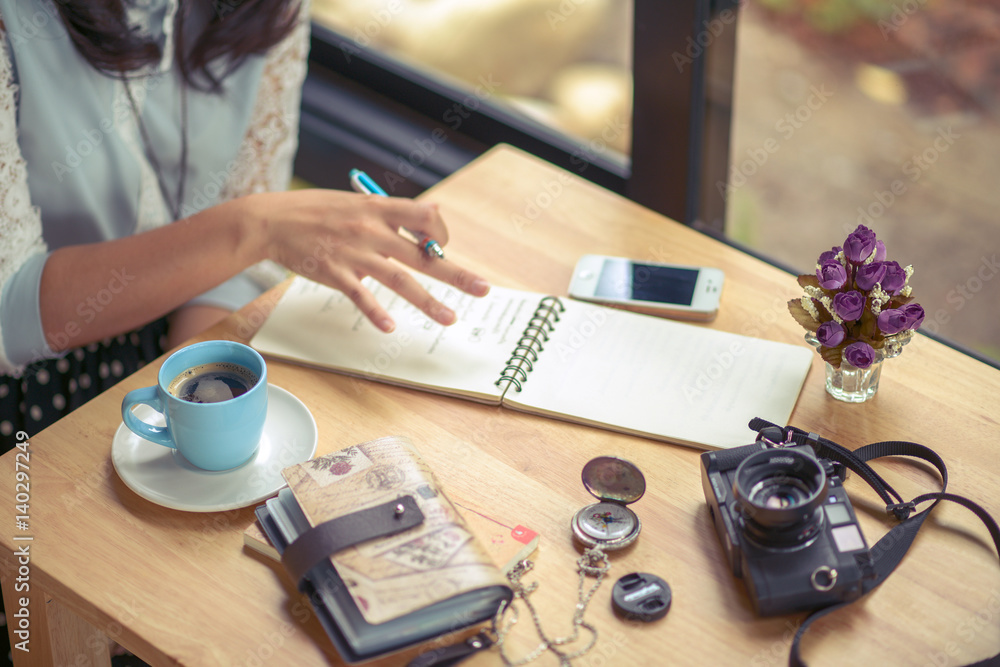 Fototapeta premium Coffee table with notebook, camera, diary, compass, and mobile phone
