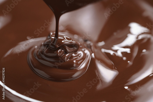 premium dark chocolate pour in bowl, shallow focus