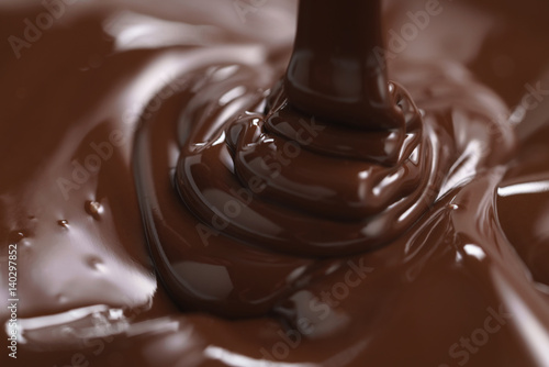 premium dark chocolate pour in bowl, shallow focus