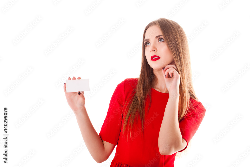 Young stylish and beautiful model girl with a smile different emotions, red lipstick in a red dressholds a sheet of white paper with free space for an inscription isolate on a white background Young stylish and beautiful model girl with a smile different emotions, red lipstick in a red dressholds a sheet of white paper with free space for an inscription isolate on a white background
