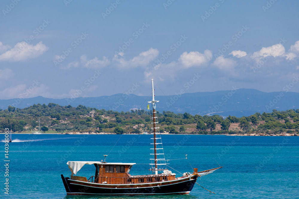 photo of cute fishing boat in front of wonderful sea and island background in Greece photo of cute fishing boat in front of wonderful sea and island background in Greece