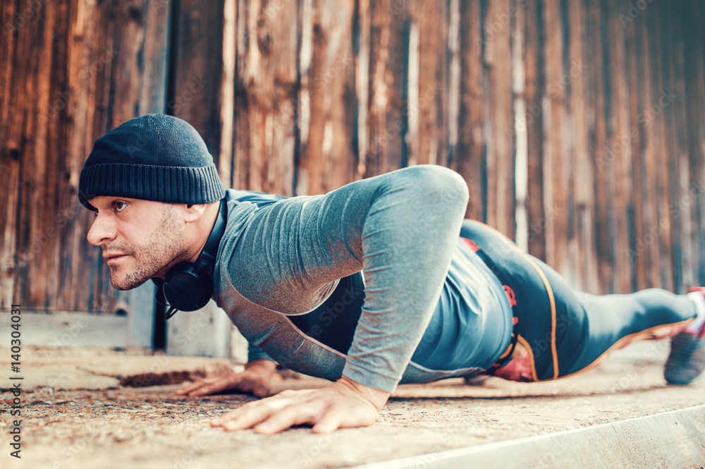 Young sportsman during his training outdoors. Sport, fitness, street workout concept Young sportsman during his training outdoors. Sport, fitness, street workout concept