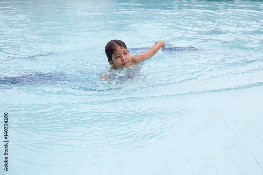 8 years old Asian kid swimming lonely in clean swimming pool at sport club