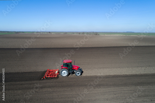 Tractor harrowing soil in spring
