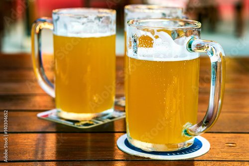 Mugs of beer on wooden table