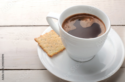 black coffee with biscuits on a wooden table