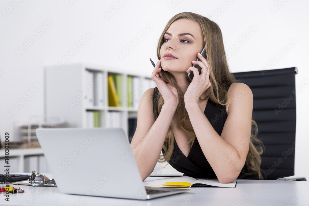 Thoughtful woman in a dress on a phone Thoughtful woman in a dress on a phone