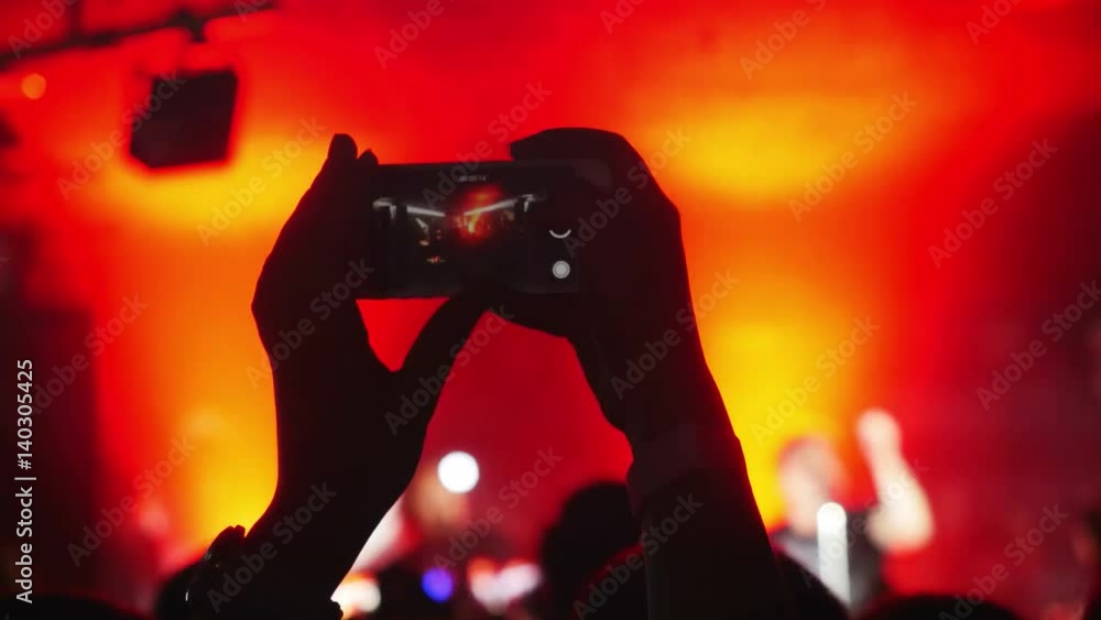 Fans waving their hands and hold the phone with digital displays the crowd at a rock concert. 3840x2160 Fans waving their hands and hold the phone with digital displays the crowd at a rock concert. 3840x2160