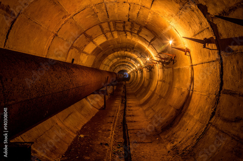 Round underground technical tunnel of heating duct with rusty pipeline 