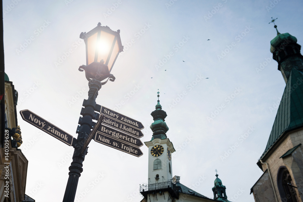 Sign post streetlight and townhall tower of Banska Stiavnica, Slovakia at dusk, UNESCO site