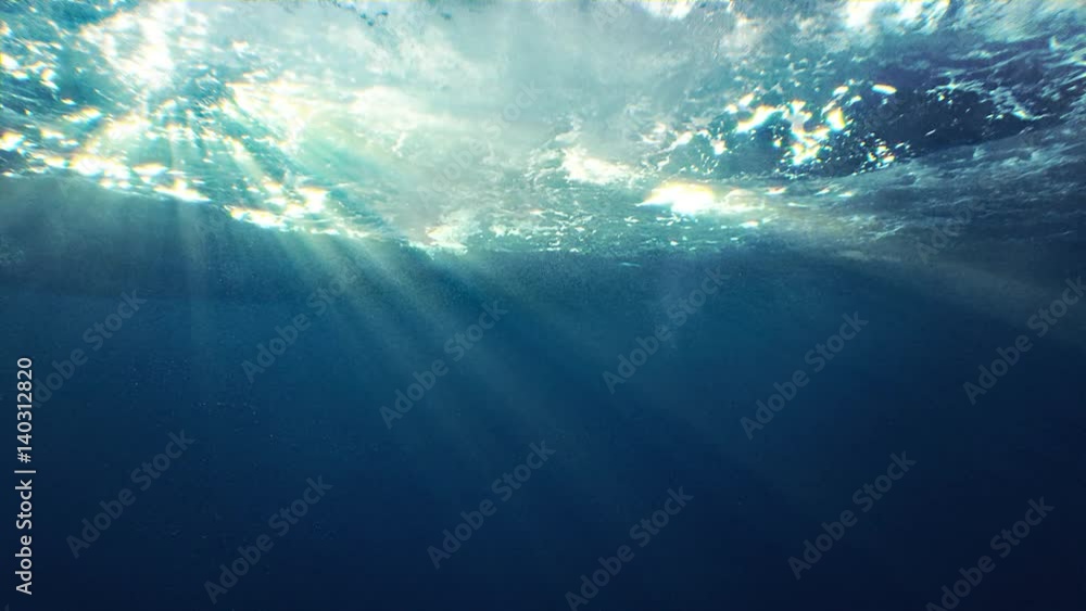 Beautiful underwater sea scene view with natural light rays, shining through the water's glittering and moving surface, caustics, bubbles, and foam, perfect for background and digital composition