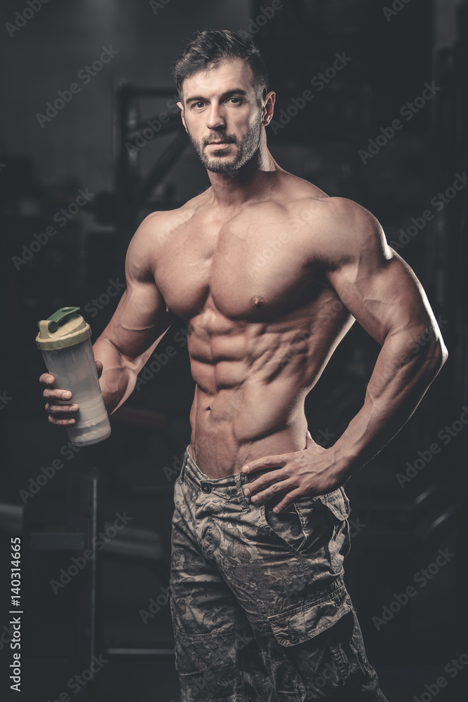 Muscular Man Resting After Exercise And Drinking From Shaker Muscular Man Resting After Exercise And Drinking From Shaker