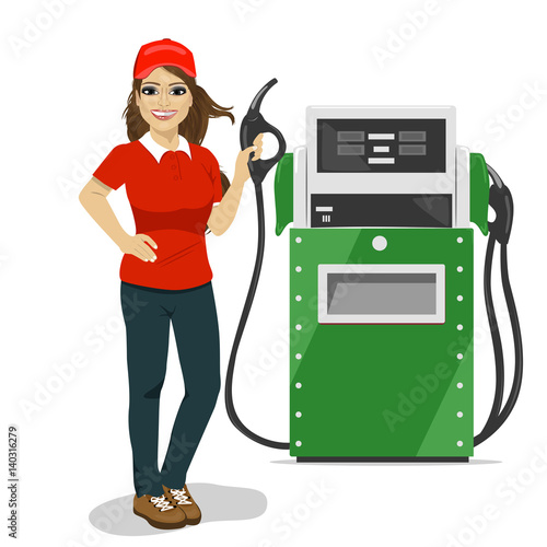 Female gas station worker holding petrol pump standing next to fuel dispenser