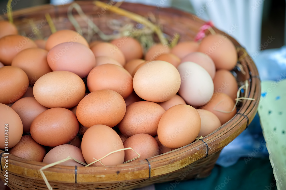 Eggs in a basket weave on market organic vegetables. Eggs in a basket weave on market organic vegetables.