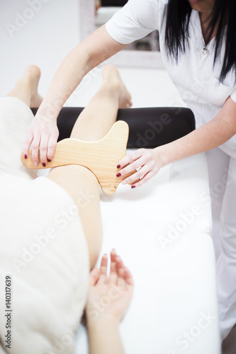 Anti cellulite massage for young woman with rolling pins