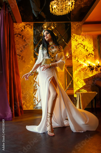 Young queen in the rich chambers. The girl is dressed in a Greek dress and go...