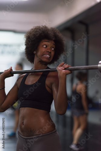 black woman lifting empty bar