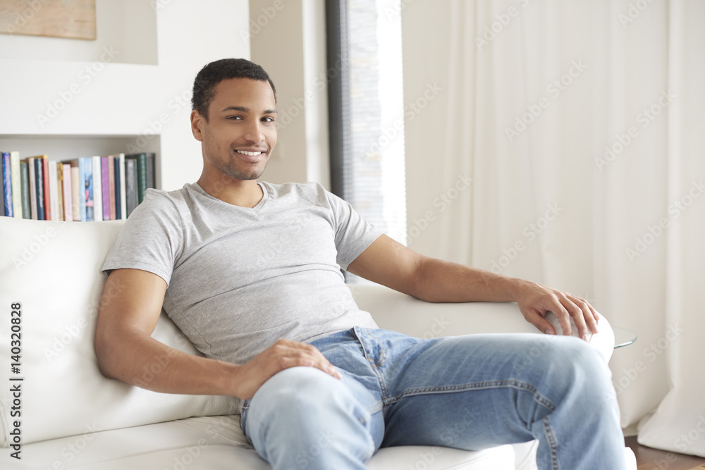 Relaxed afro man. Shot of a handsome man sitting in his modern home.