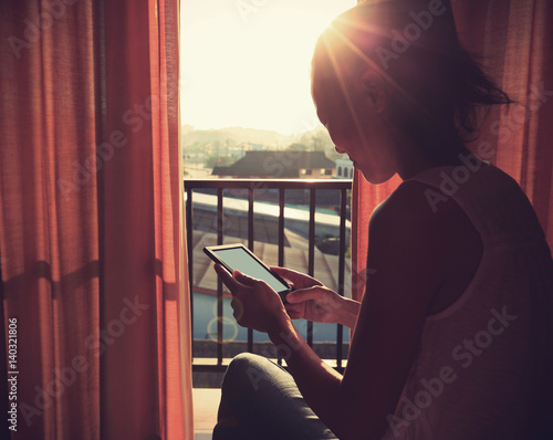 young woman reading book at sunrise bedroom in the morning