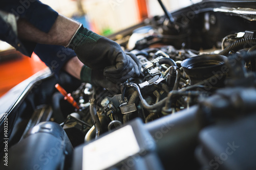 Canvas-taulu Close up hands of unrecognizable mechanic doing car service and maintenance