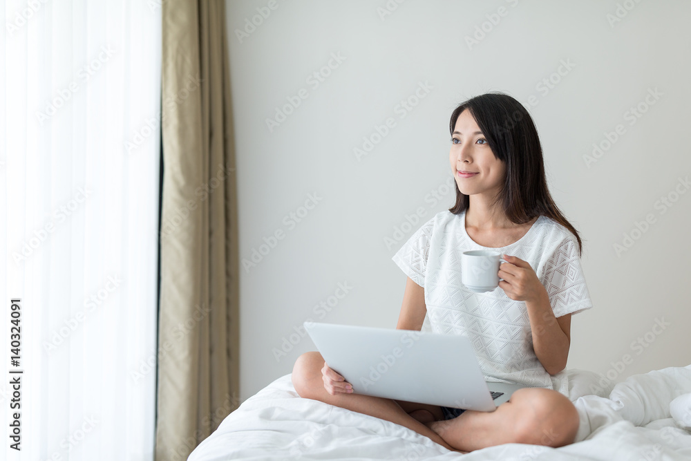 Woman working with notebook computer and enjoy her coffee at home Woman working with notebook computer and enjoy her coffee at home