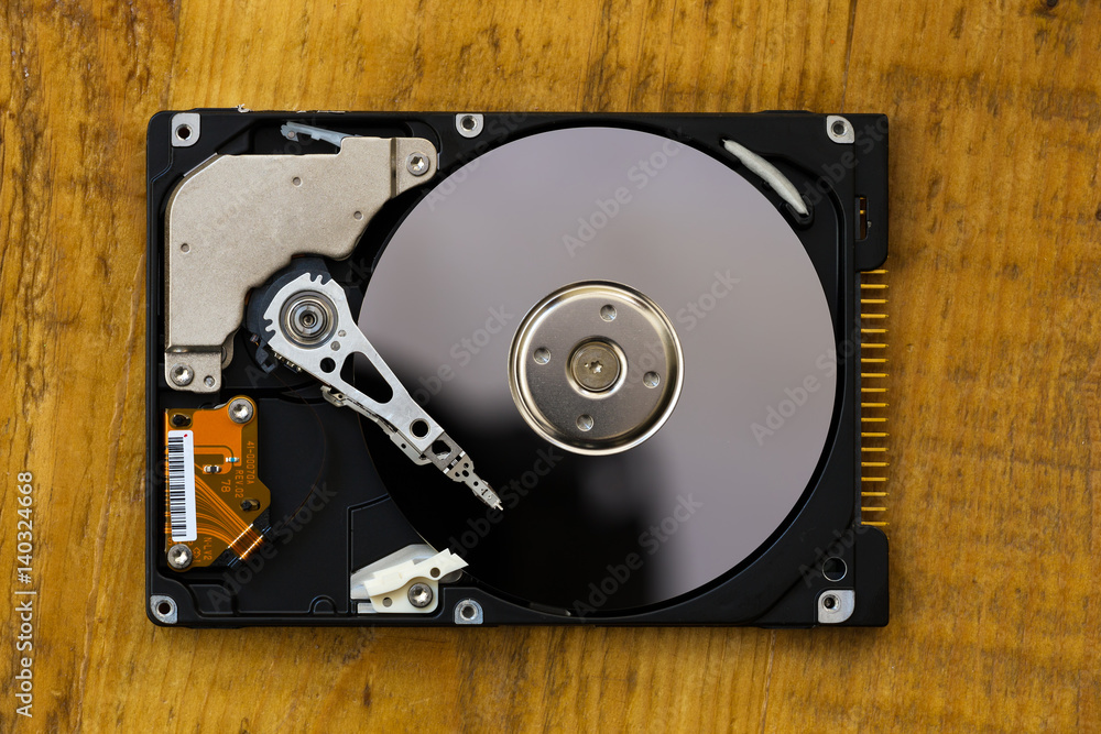 Opened hard drive from the computer on wooden background Opened hard drive from the computer on wooden background