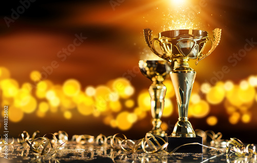 Champion golden trophy on wood table with spot lights on background